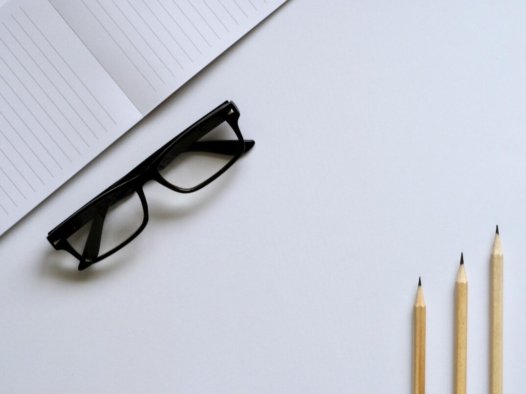 Desk with documents, pen and reading glasses